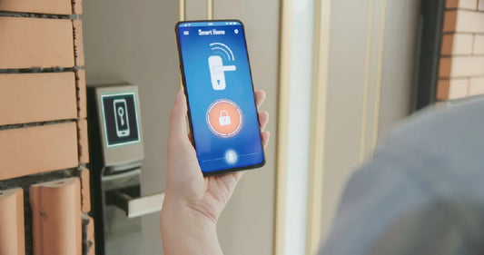 Close up of a hand holding a smartphone with a smart home app to unlock a front door